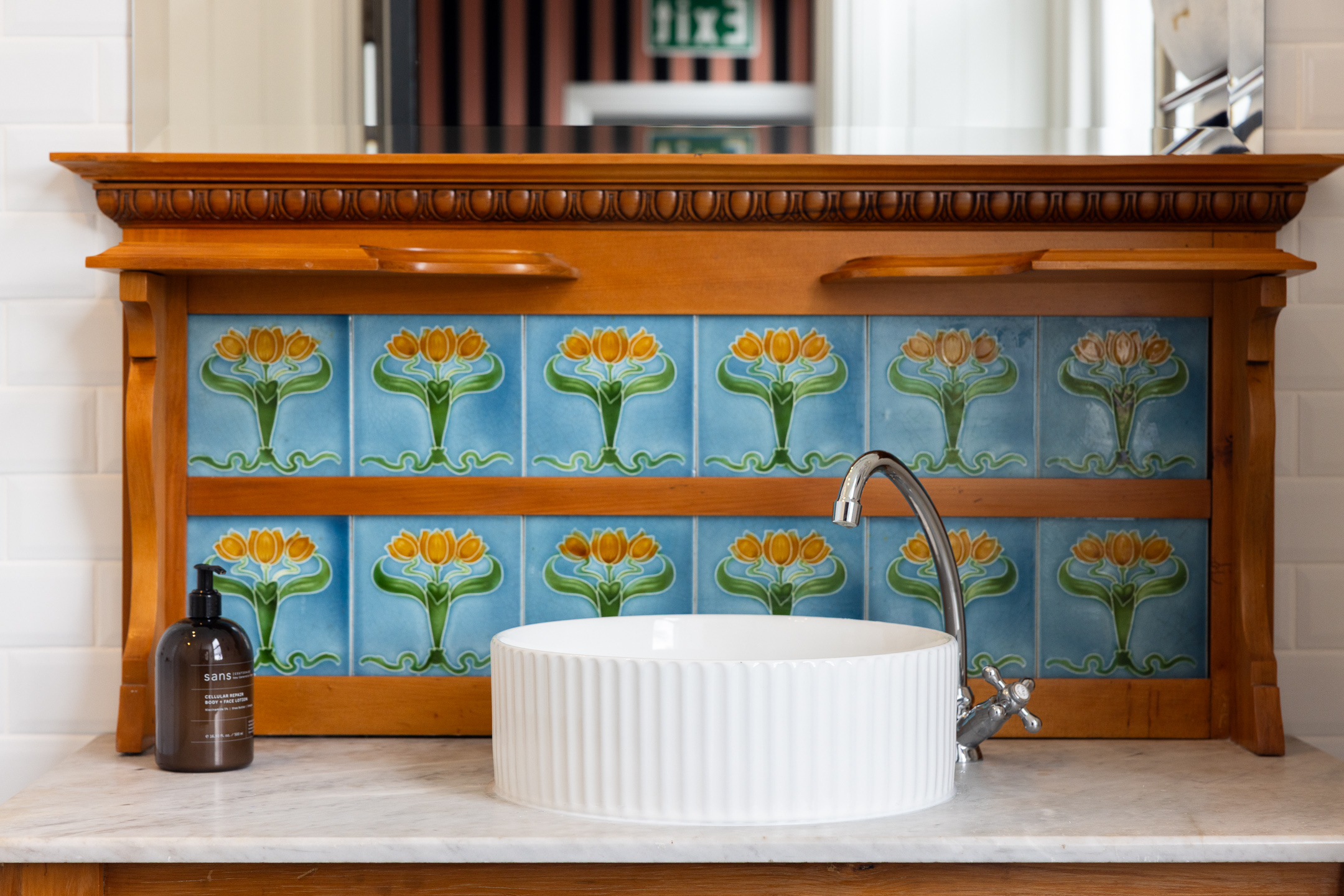 Handpainted tiles decorate the back of the antique vanity unit in the bathroom of the McFarlane Room at Hulbert House